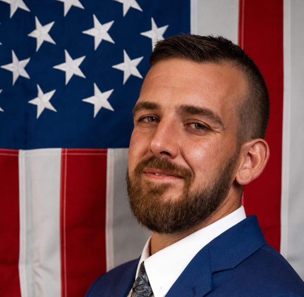 Chris Bellingham, candidate for Deltona City Commission District 5, photographed in front of an American flag